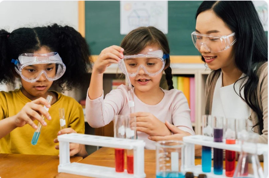 Diverse children doing science experiment with teacher